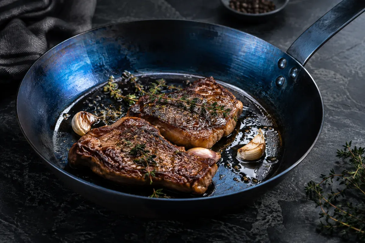 A blue carbon steel pan with a tempered blue finish