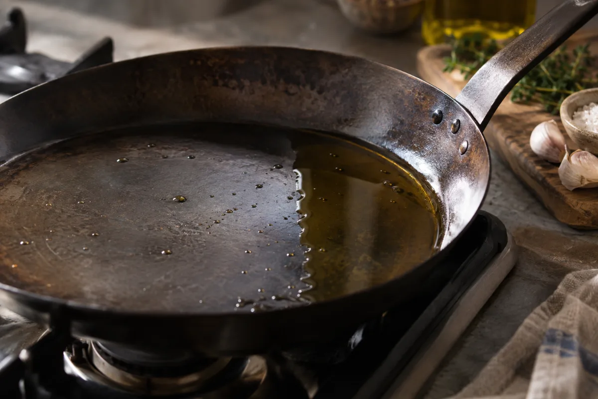 Oil pooling on one side of a warped carbon steel pan